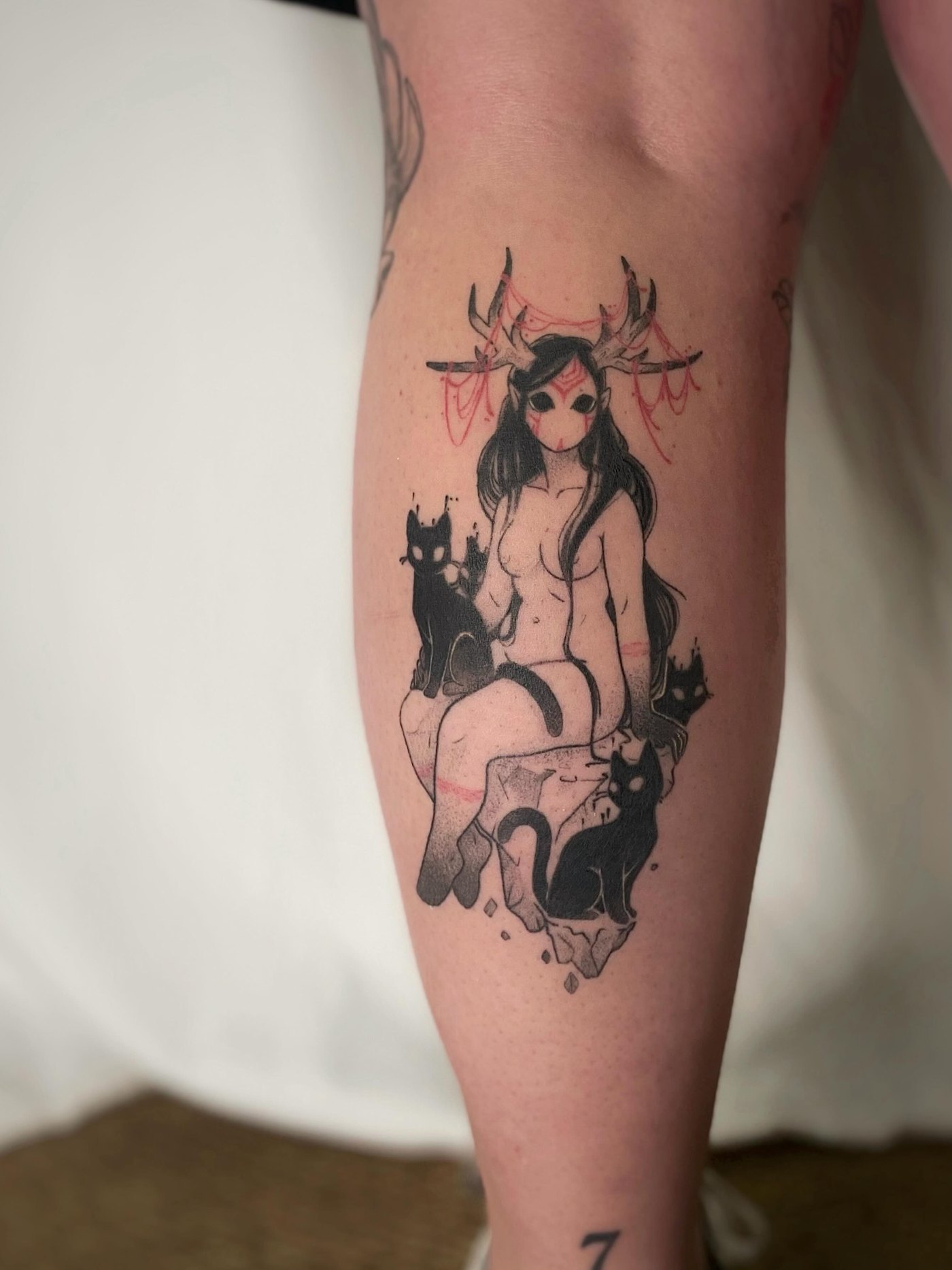 Tatouage illustratif d'une figure gothique avec des chats noirs