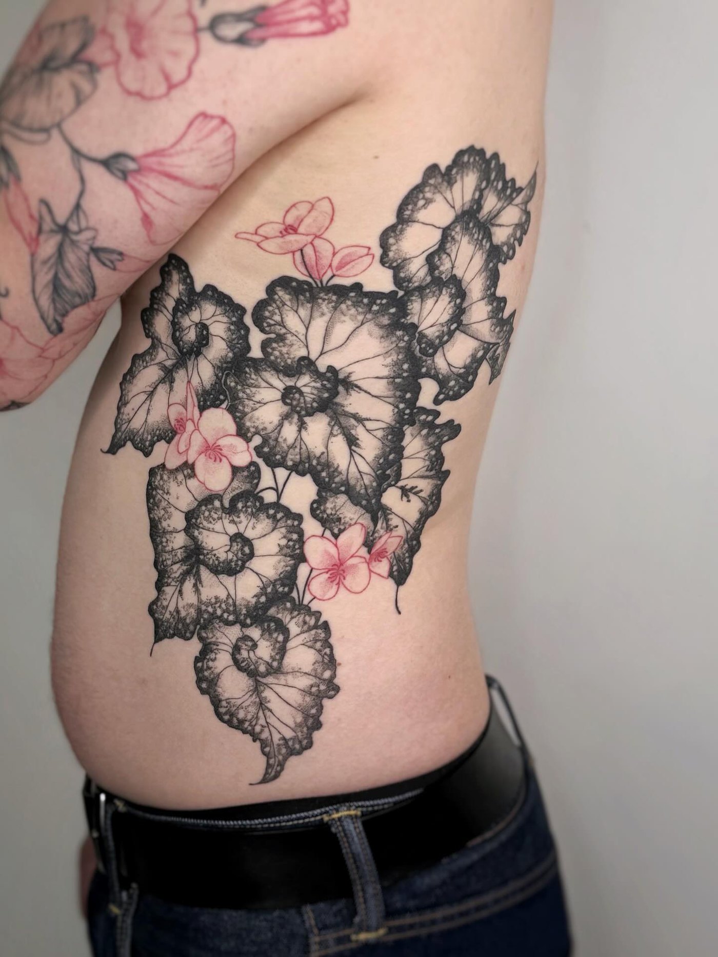 Tatouage floral en noir sur le flanc